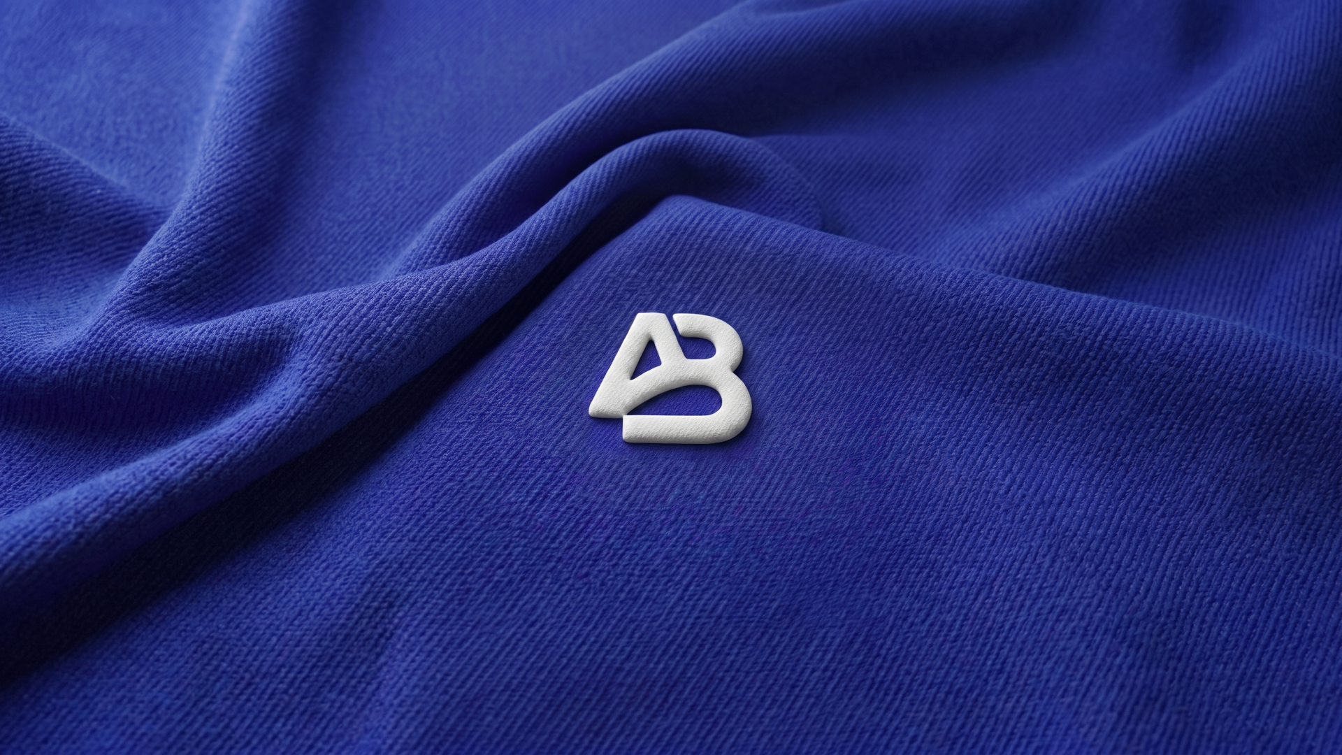 ArcheryBeauty Monogram Substrate Badge on Deep Indigo Draped Fabric